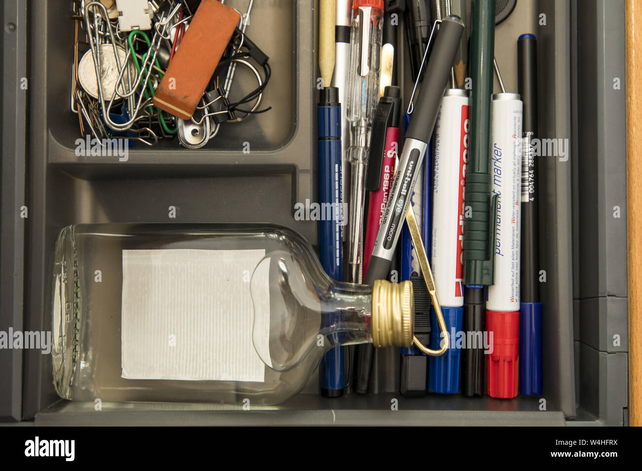 Symbol image addiction, alcohol, liquor, hidden at work, in the office drawer, Stock Photo