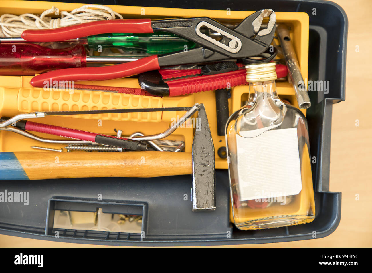 Symbol image addiction, alcohol, liquor, at work, craftsman, tool box, Stock Photo