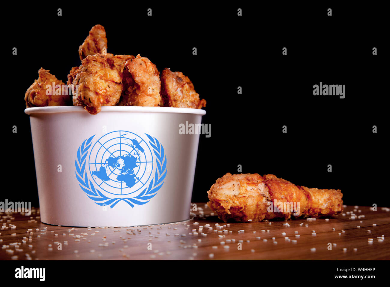 BBQ Chicken wings in bucket flag of UN on a wooden table and black background. Stock Photo