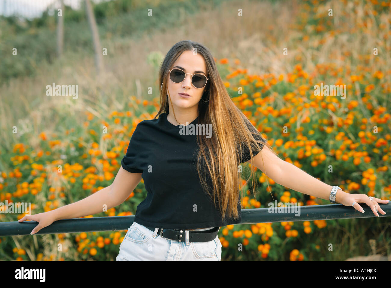 Young beautiful woman posing in flowers field Stock Photo