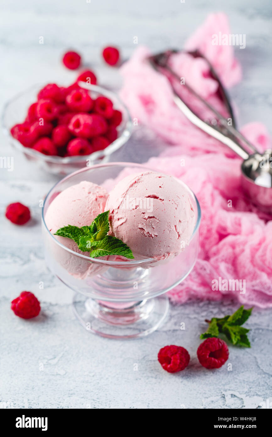 Raspberry ice cream balls with berries and mint leaves in bowl Stock ...