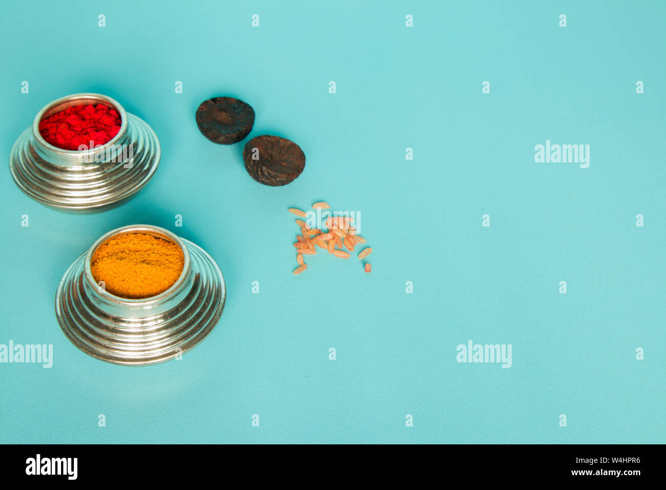 Sindoor or Kumkum silver box, areca and rice on blue background used in Hindu religion Stock Photo