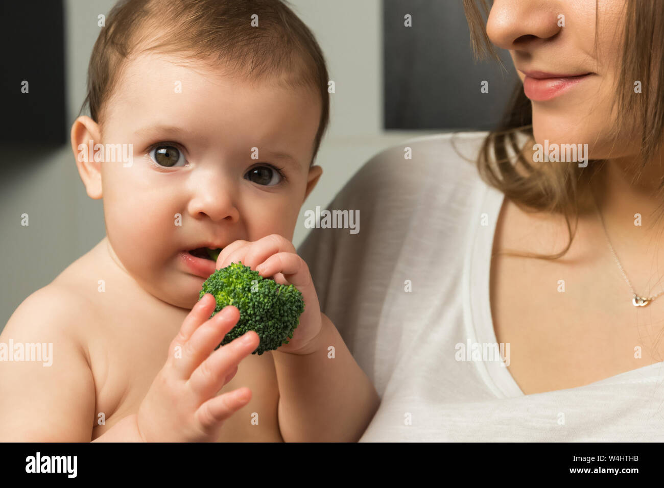 Young mother feeds baby broccoli Stock Photo Alamy