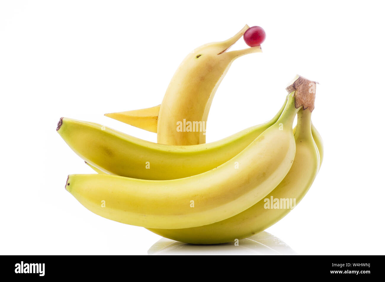 decorated banana forms a fish and bunch of bananas isolated from the white background Stock Photo