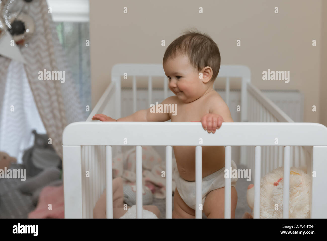 Baby Girl In A Diaper Playing In The Crib Stock Photo 261007897