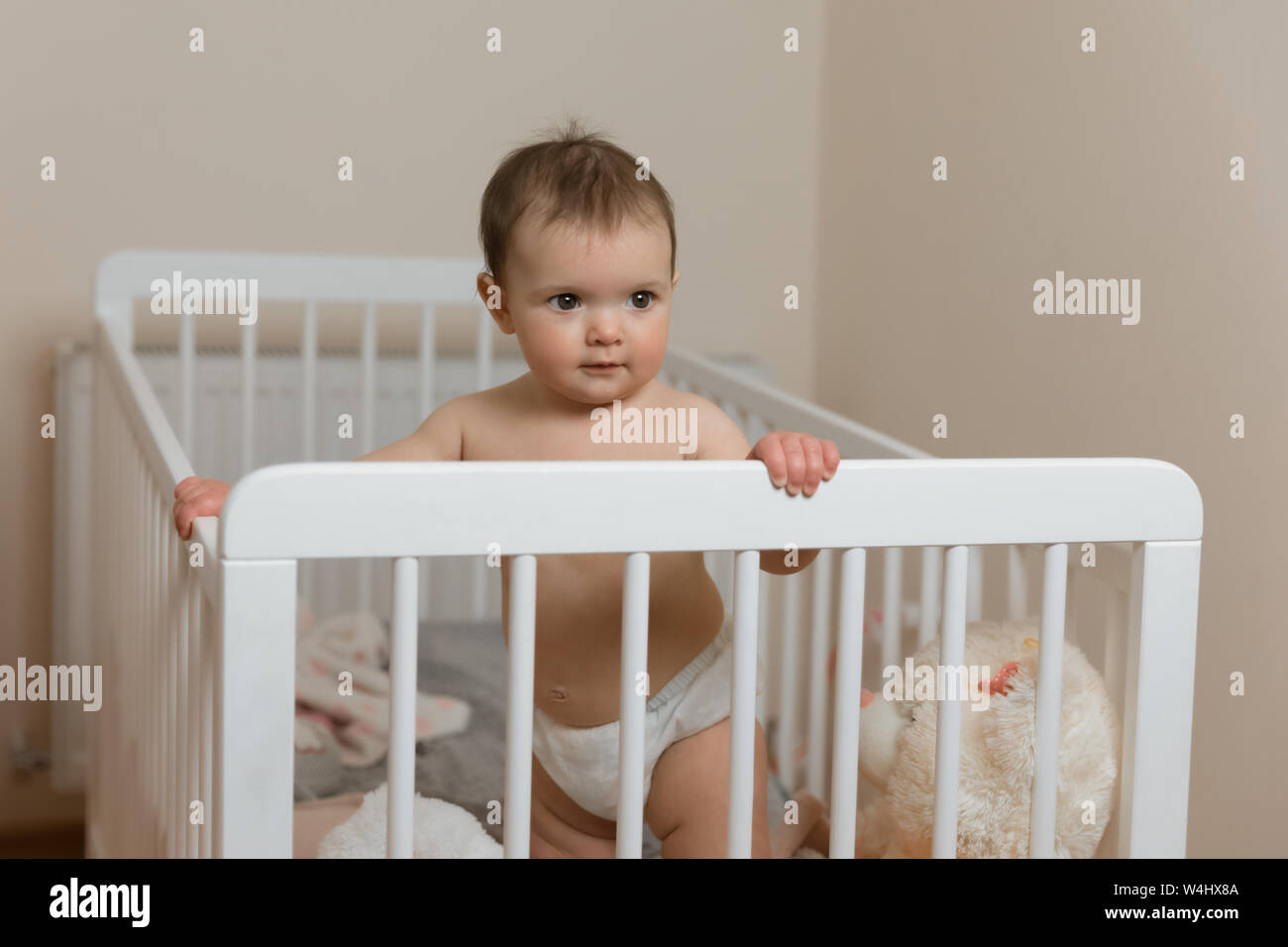 Baby Girl In A Diaper Playing In The Crib Stock Photo 261007946