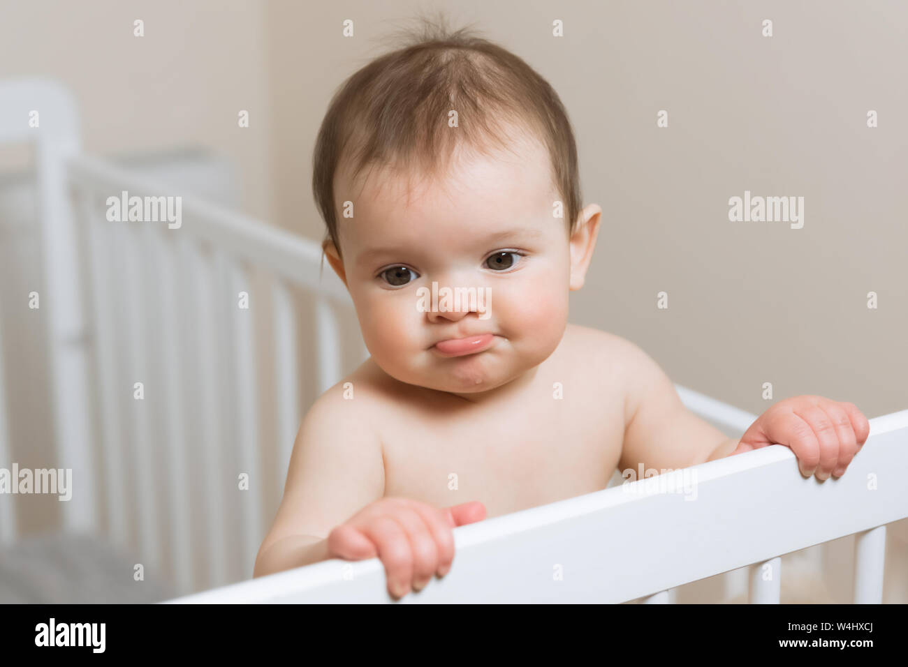 Baby girl in a diaper playing in the crib. Very funny face expression Stock  Photo - Alamy