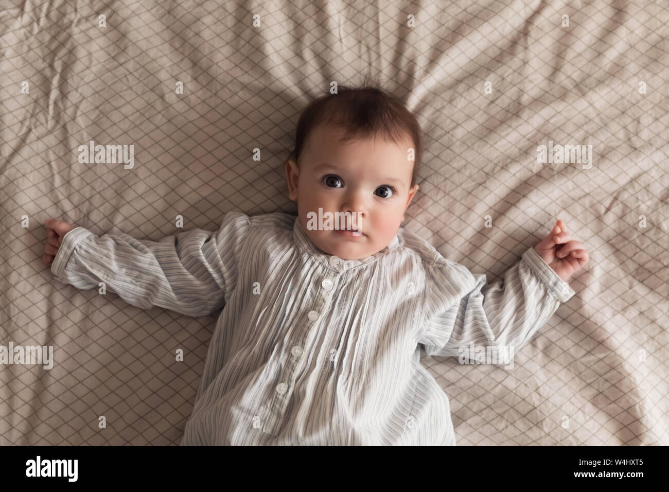 Cute newborn girl lying on the bed. The baby wants to sleep in the parent's bed Stock Photo Alamy