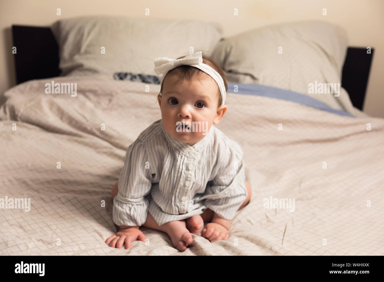 Cute newborn girl lying on the bed. The baby wants to sleep in the