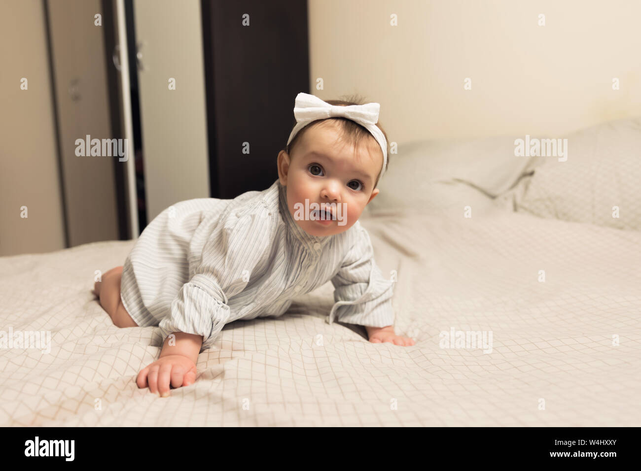 Cute newborn girl lying on the bed. The baby wants to sleep in the