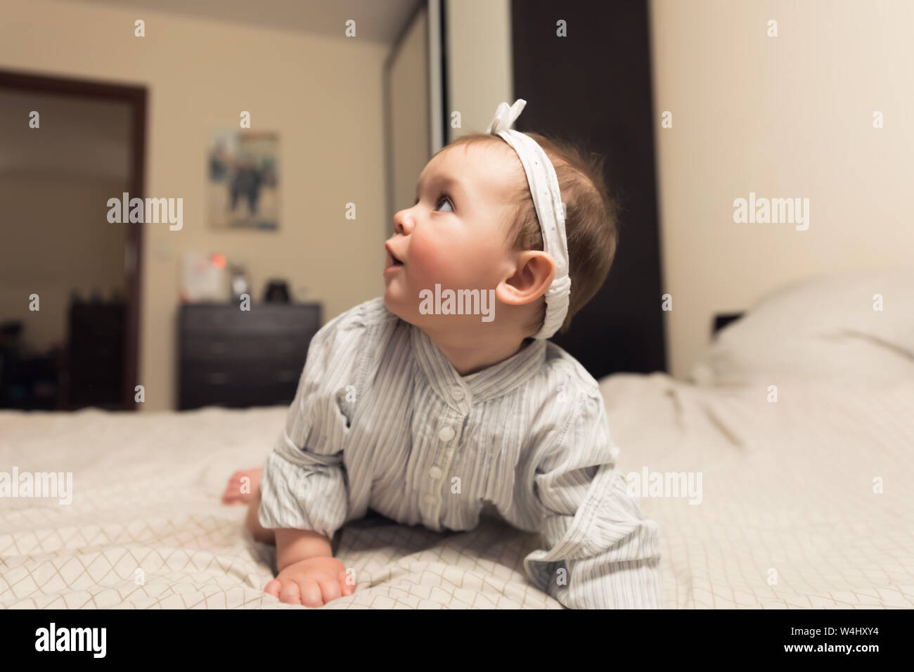 Cute newborn girl lying on the bed. The baby wants to sleep in the