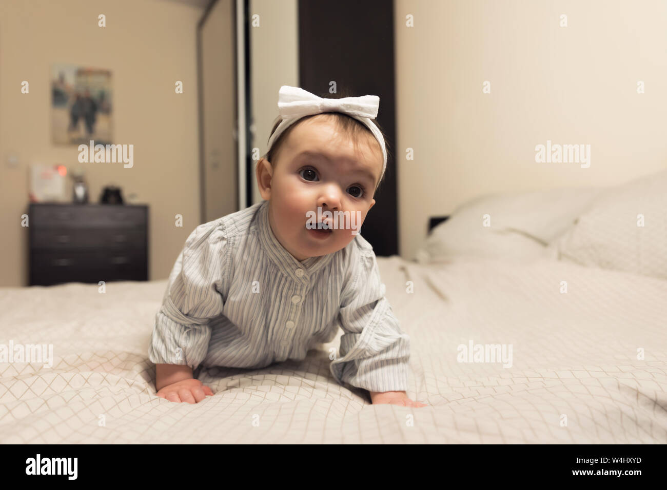 Cute newborn girl lying on the bed. The baby wants to sleep in the
