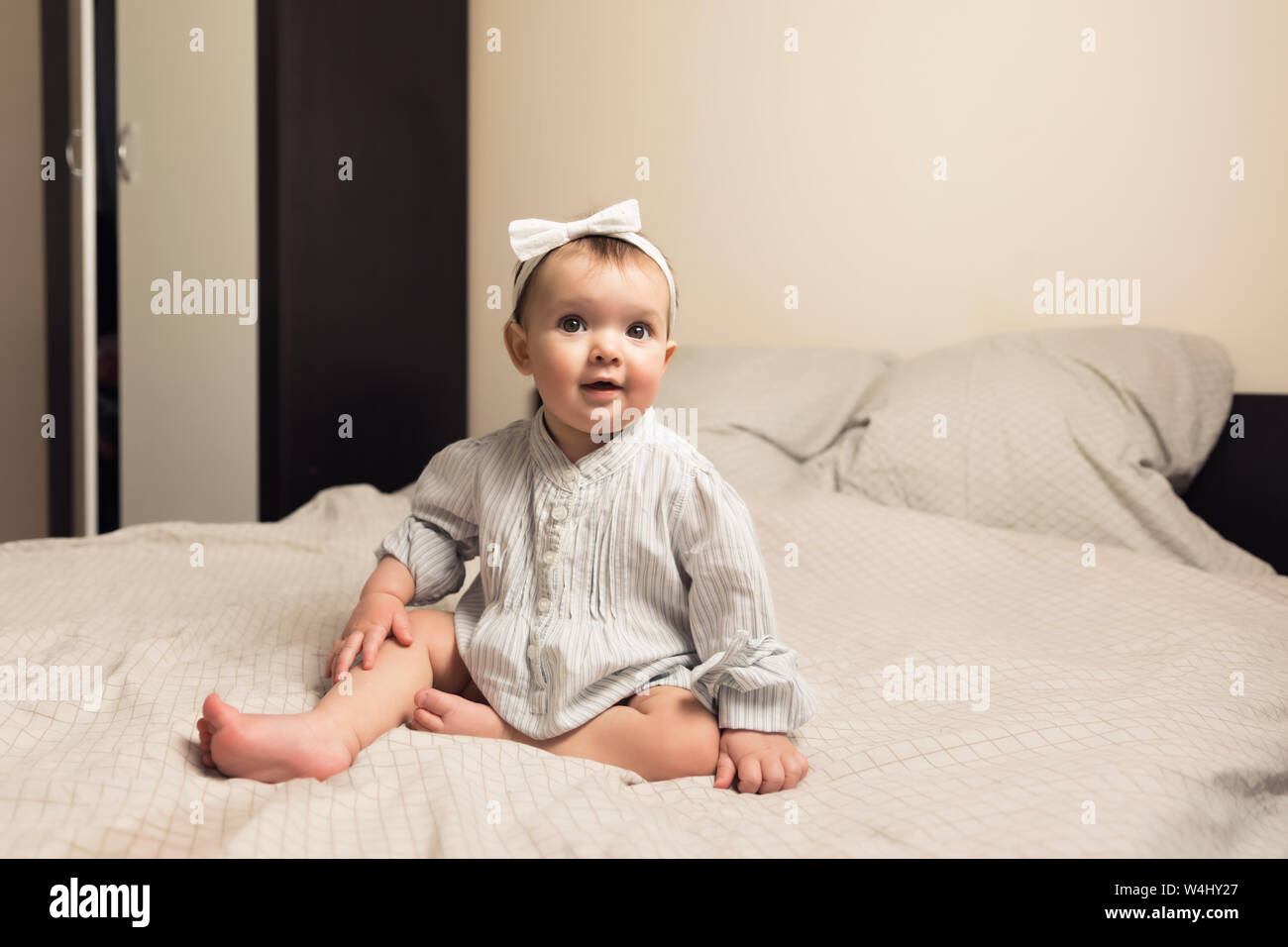 Cute newborn girl lying on the bed. The baby wants to sleep in the