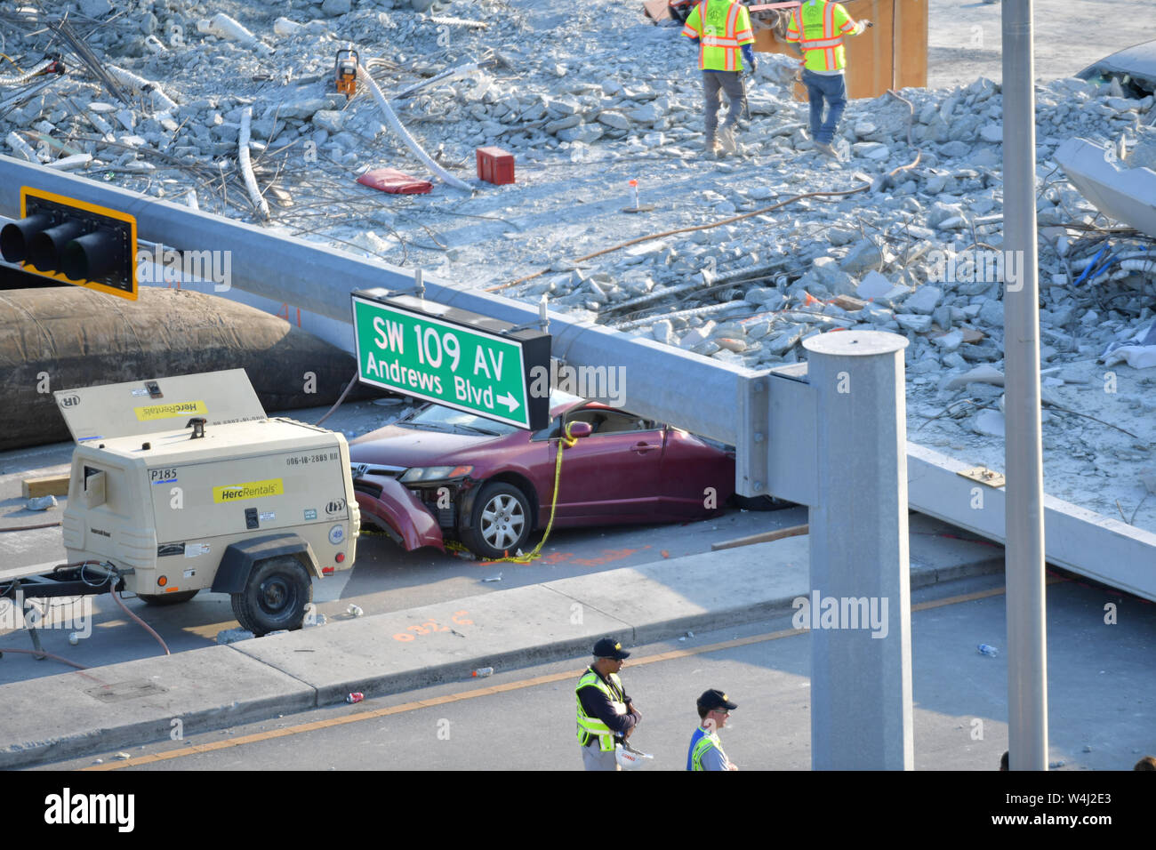 MIAMI, FL - MARCH 17: Crack on Florida Bridge Was Discussed in Meeting Hours Before Collapse - Scene where a pedestrian bridge collapsed a few days after it was built over southwest 8th street allowing people to bypass the busy street to reach Florida International University on March 17, 2018 in Miami, Florida. Reports indicate that there are at least 6 fatalities as a result of the collapse, which crushed at least five cars. Fireman remove rubble delicately by hand in respect for the deceased and their families  People:  Atmosphere Stock Photo
