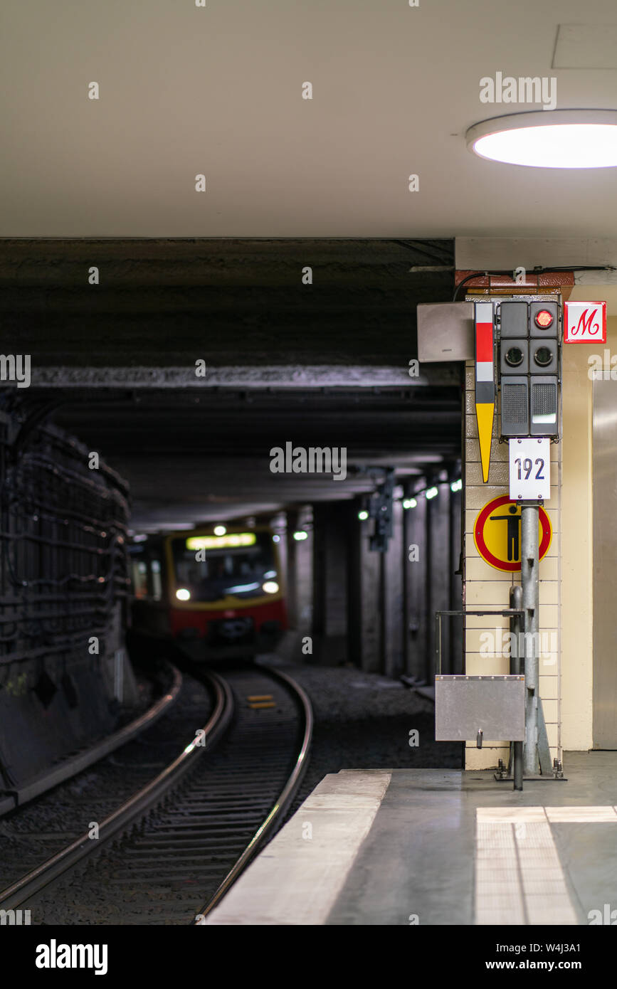 Nordbahnhof, Berlin, Germany - july 07, 2019: view from the platform into the illuminated railway tunnel with a train approaching in the distance Stock Photo