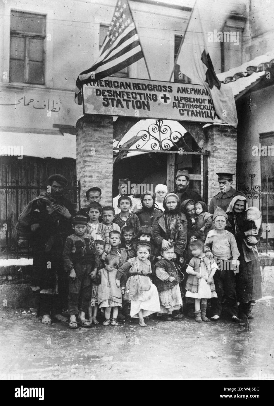 Refugees of Serbia entering Uskut, Ukraine. Group of men, women and children in front of an American Red Cross disinfecting Station before they entered shelters. American Red Cross. Circa.1917-19. Stock Photo