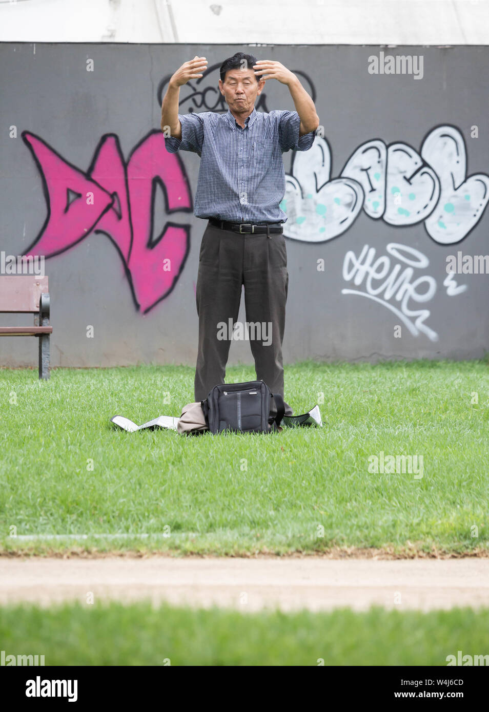 Businessman performing Falun Dafa / Falun Gong /meditation/mindfulness in city park. Stock Photo