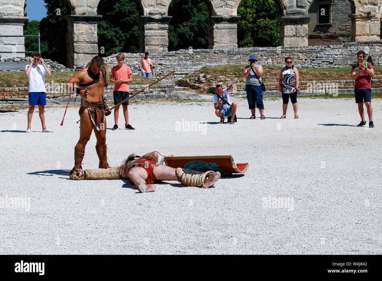 Tourists watch as actors stage gladiator battle in Pula Arena, a Roman amphitheatre built in Croatia in the 1st century AD Stock Photo