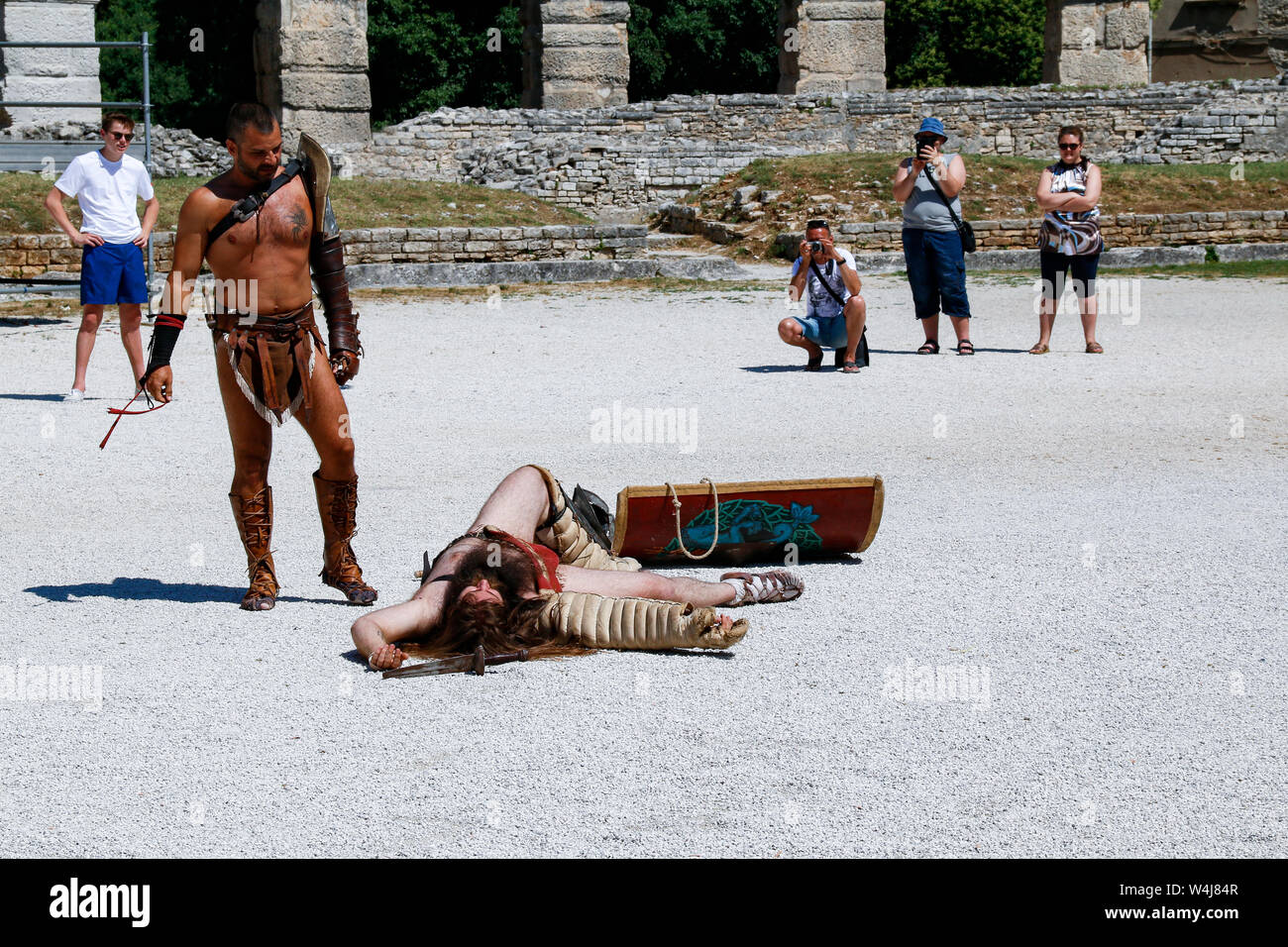 Tourists watch as actors stage gladiator battle in Pula Arena, a Roman amphitheatre built in Croatia in the 1st century AD Stock Photo