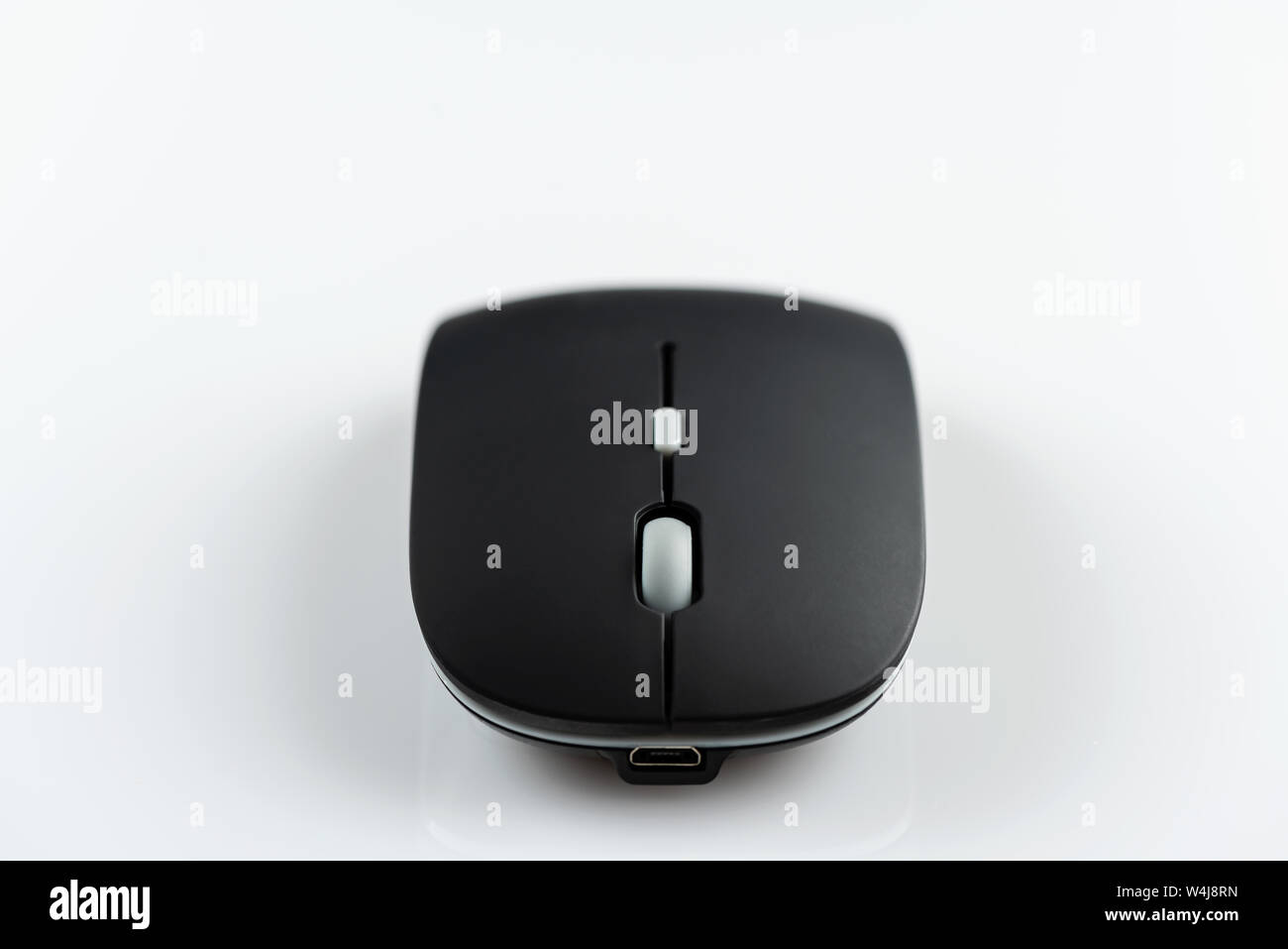 Black wireless computer mouse on a white background. Stock Photo