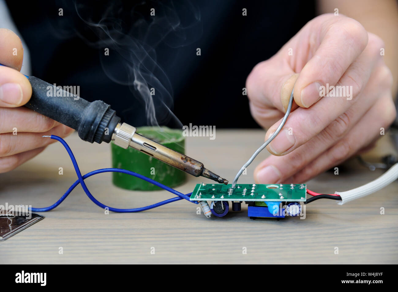 The man is repairing the power supply of the lamp. He is holding an ...