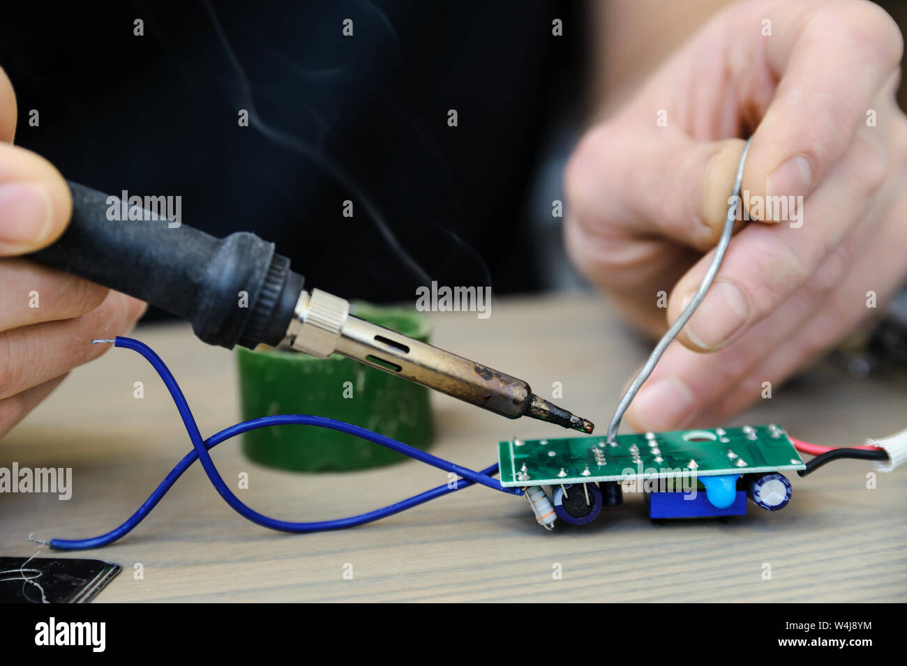 The man is repairing the power supply of the lamp. He is holding an ...