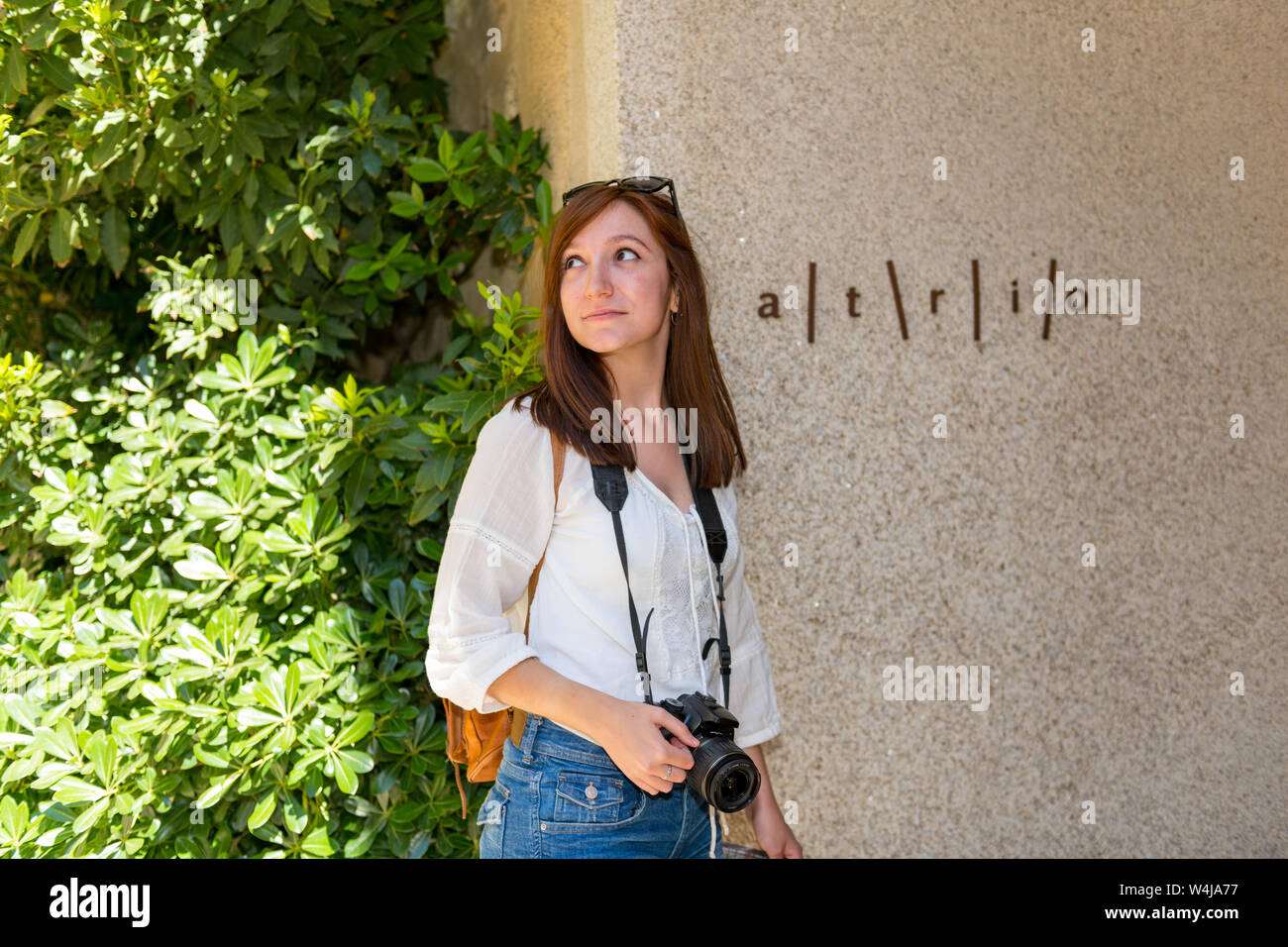 Young red-haired tourist next to the sign at the entrance of the famous Atrio Hotel-Restaurant in Caceres Stock Photo