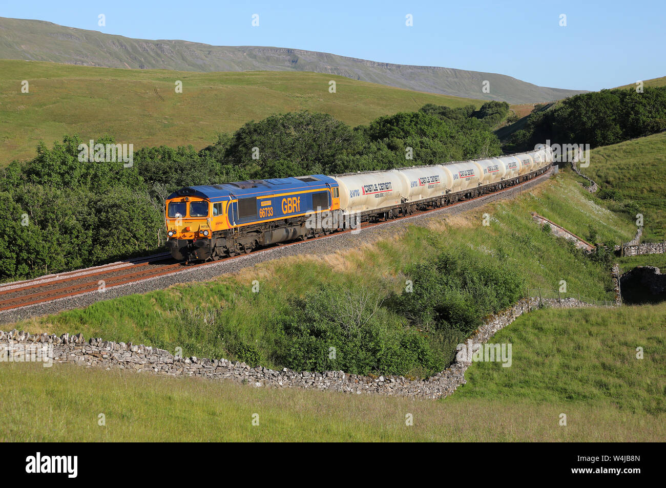 GBRF 66733 heads past Birkett Common on the Settle & Carlisle railway with the Clitheroe to Mossend cements. Stock Photo