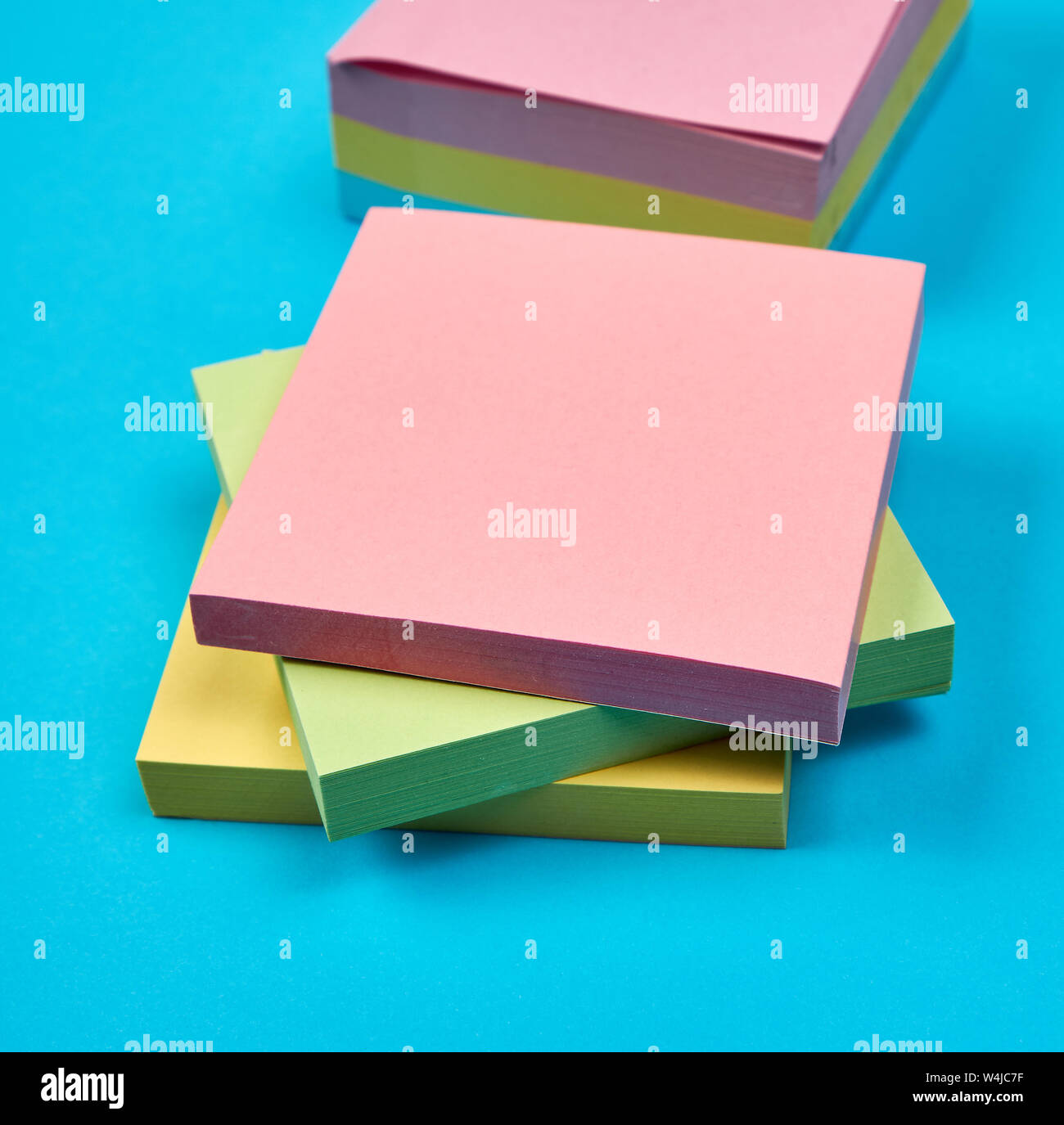 multicolored empty paper square stickers on blue background, close up Stock Photo