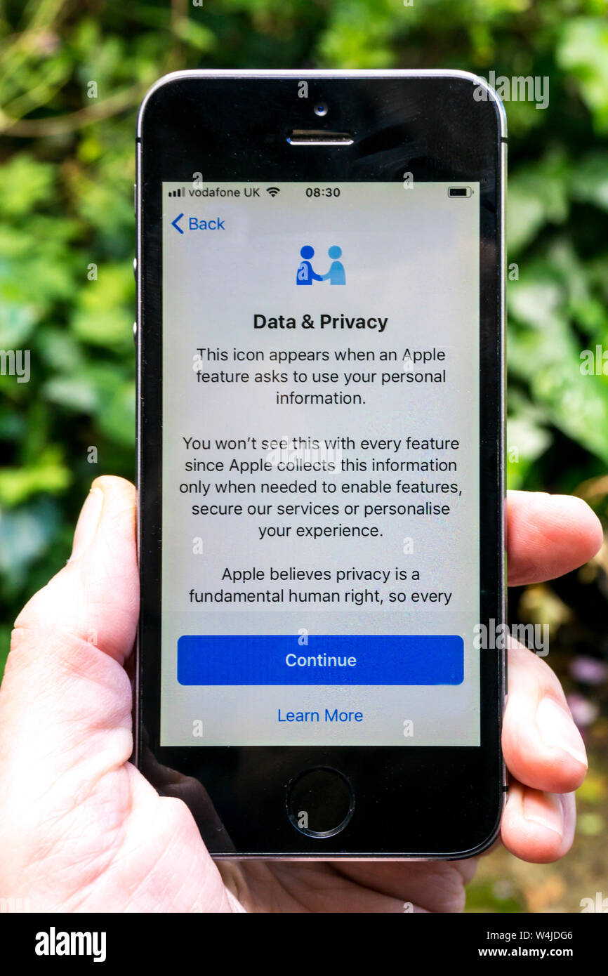 Person holding an Apple iphone displaying a message about the Data & Privacy icon. Stock Photo