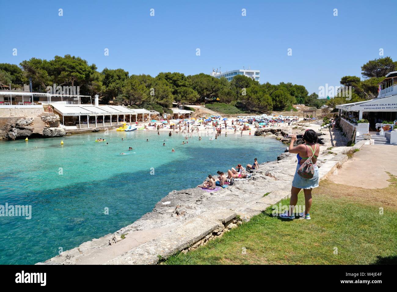 The beach and cove at Cala Blanca on a hot summers day, Menorca Balearic Islands Spain EU Stock Photo