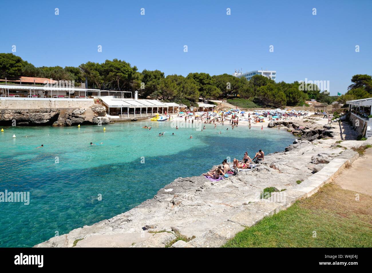 The beach and cove at Cala Blanca on a hot summers day, Menorca Balearic Islands Spain EU Stock Photo