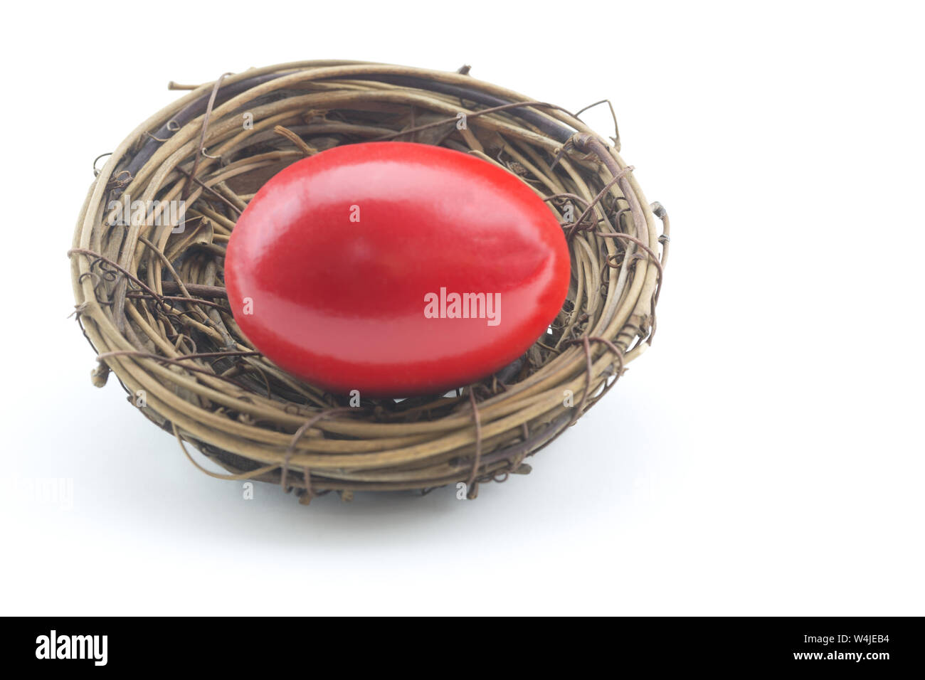 Horizontal conceptual image of financial risk displays red nest egg on white background Stock Photo
