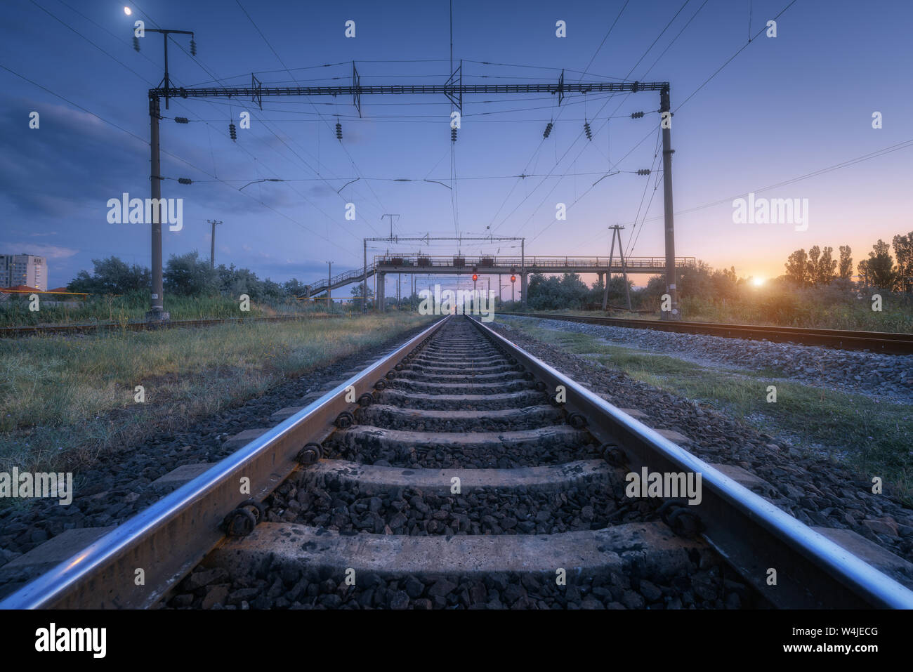 Summer rural industrial landscape with railway station at sunset Stock Photo