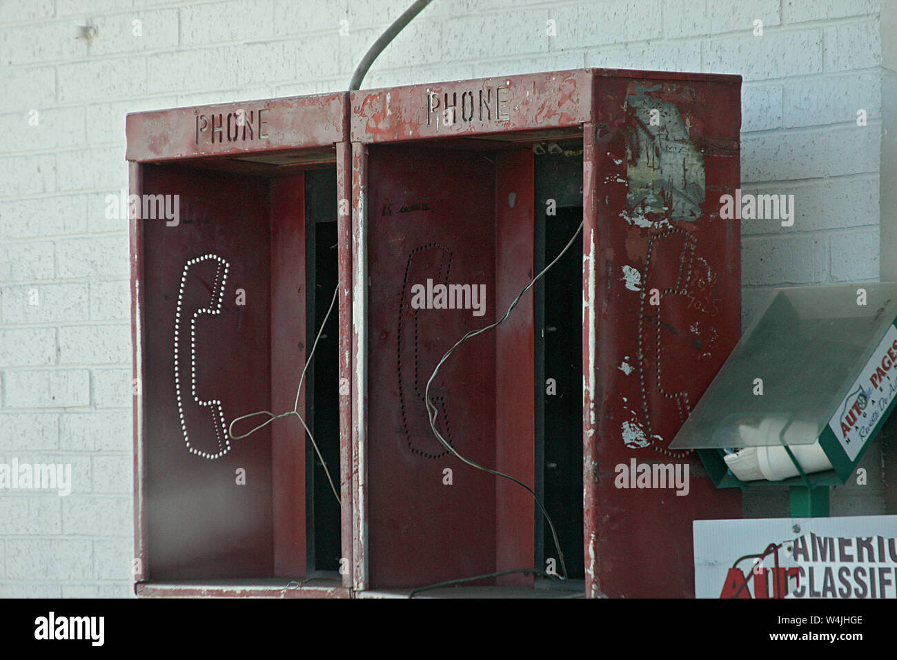 Out of use public pay phone boxes by gas station in the United States Stock Photo