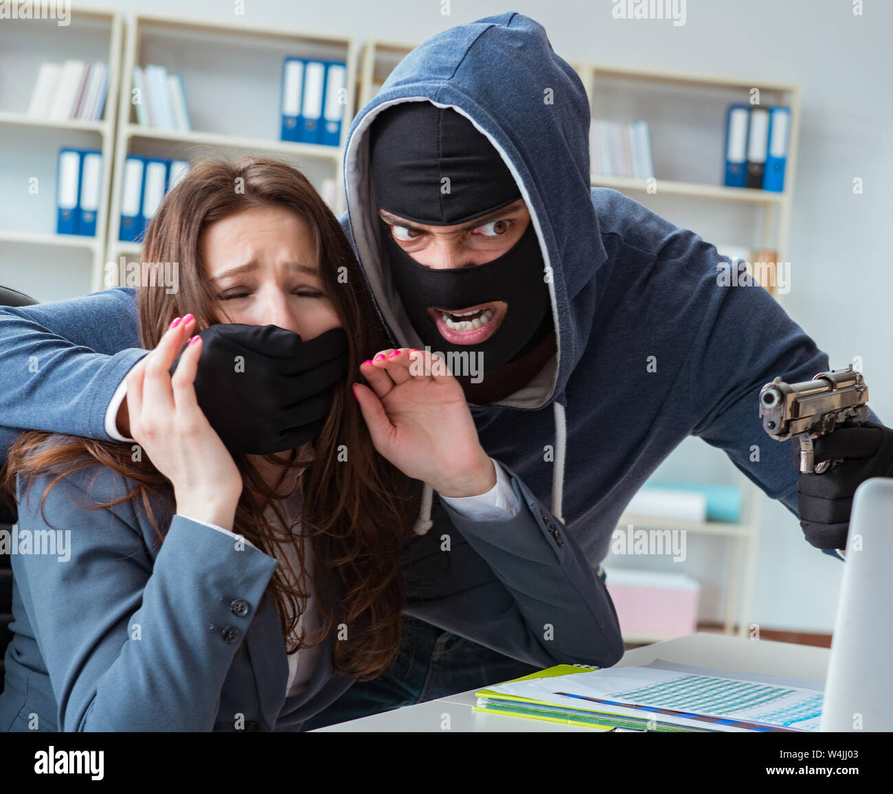 Criminal taking businesswoman as hostage in office Stock Photo - Alamy