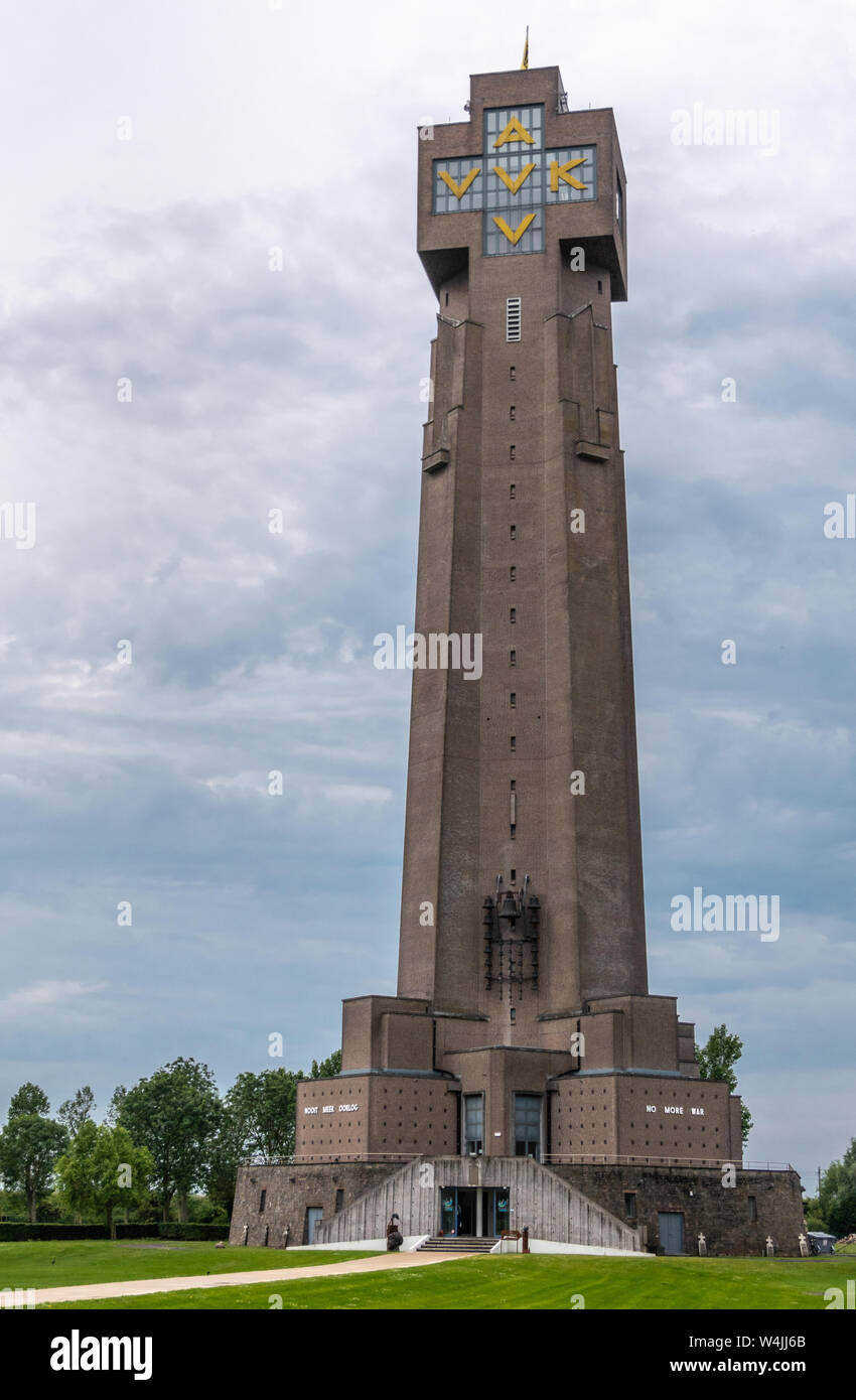 Diksmuide, Flanders, Belgium -  June 19, 2019: IJzertoren, tallest peace monument of WW 1 against gray blue cloudscape. On wall saying No More War. So Stock Photo