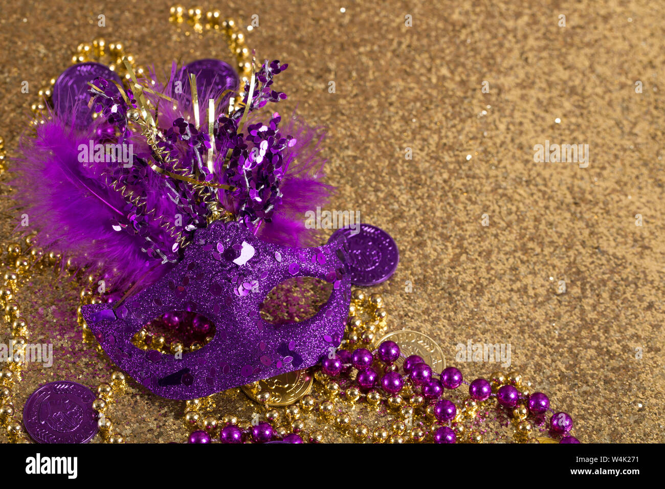 purple mardi gras mask on a gold background Stock Photo - Alamy