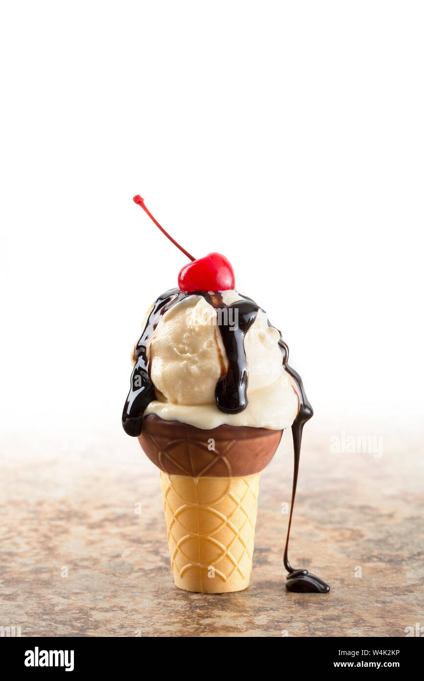 Messy ice cream cone with vanilla ice cream, chocolate syrup, and a
