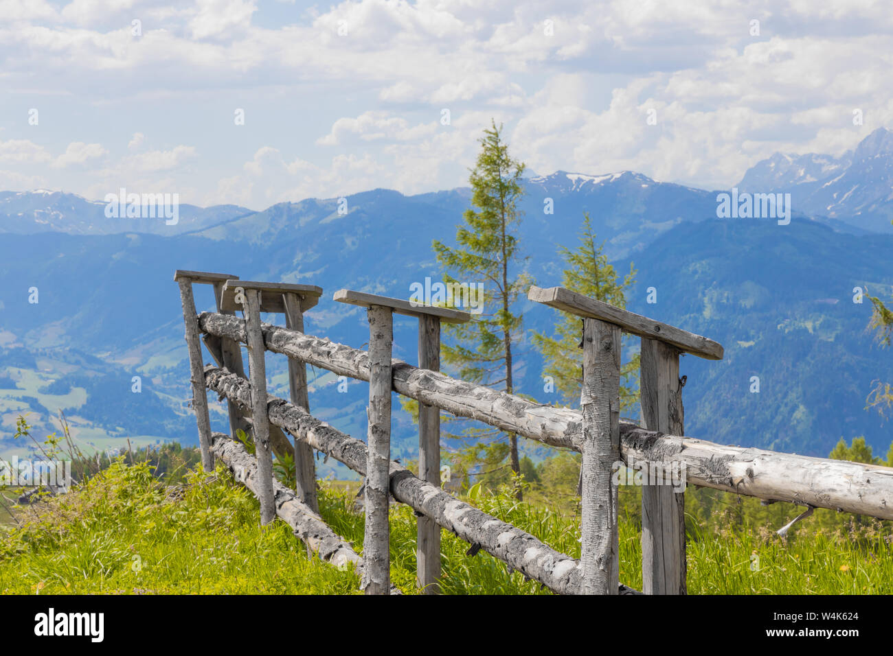 Holz Zaun auf grüner Wiese vor Alpen Panorama mit Wolken Stock Photo