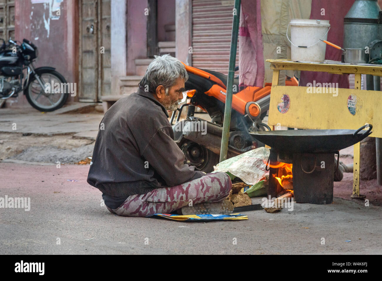 Bikaner, India - February 11, 2019: Man preparing food on fire in market at Bikaner. Rajasthan Stock Photo