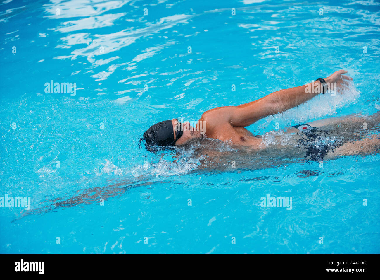 Athletic Young man swimming on Backstroke style. Swimming competition. Stock Photo