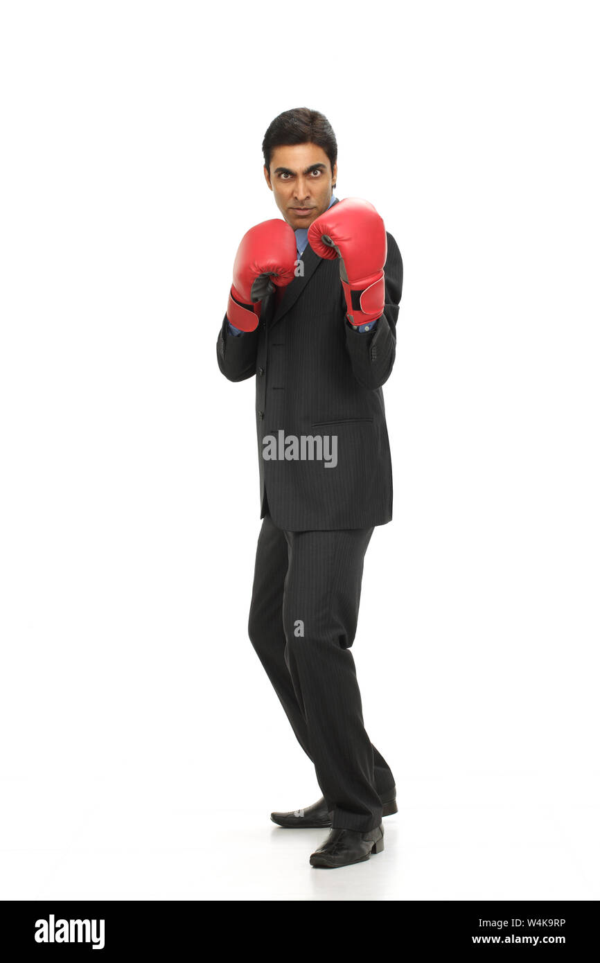 Mature businessman wearing boxing gloves hires stock photography and