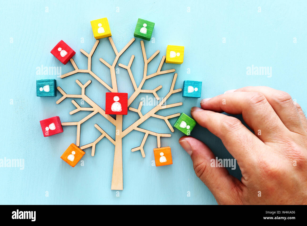 Business image of wooden tree with people icons over blue table, human ...