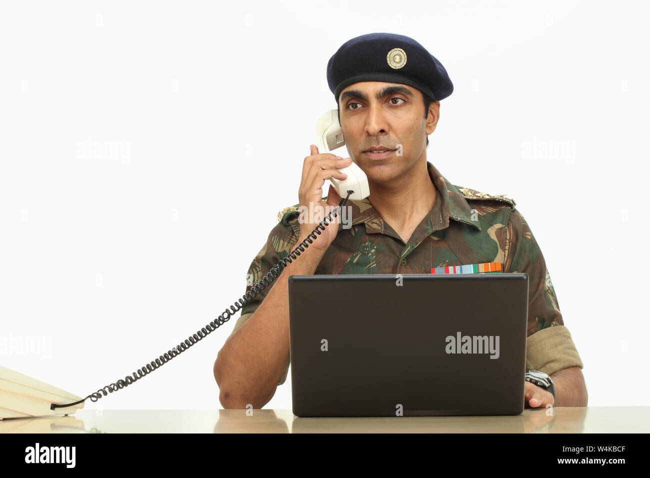 Army Soldier Talking On A Landline Phone And Using A Laptop Stock Photo -  Alamy