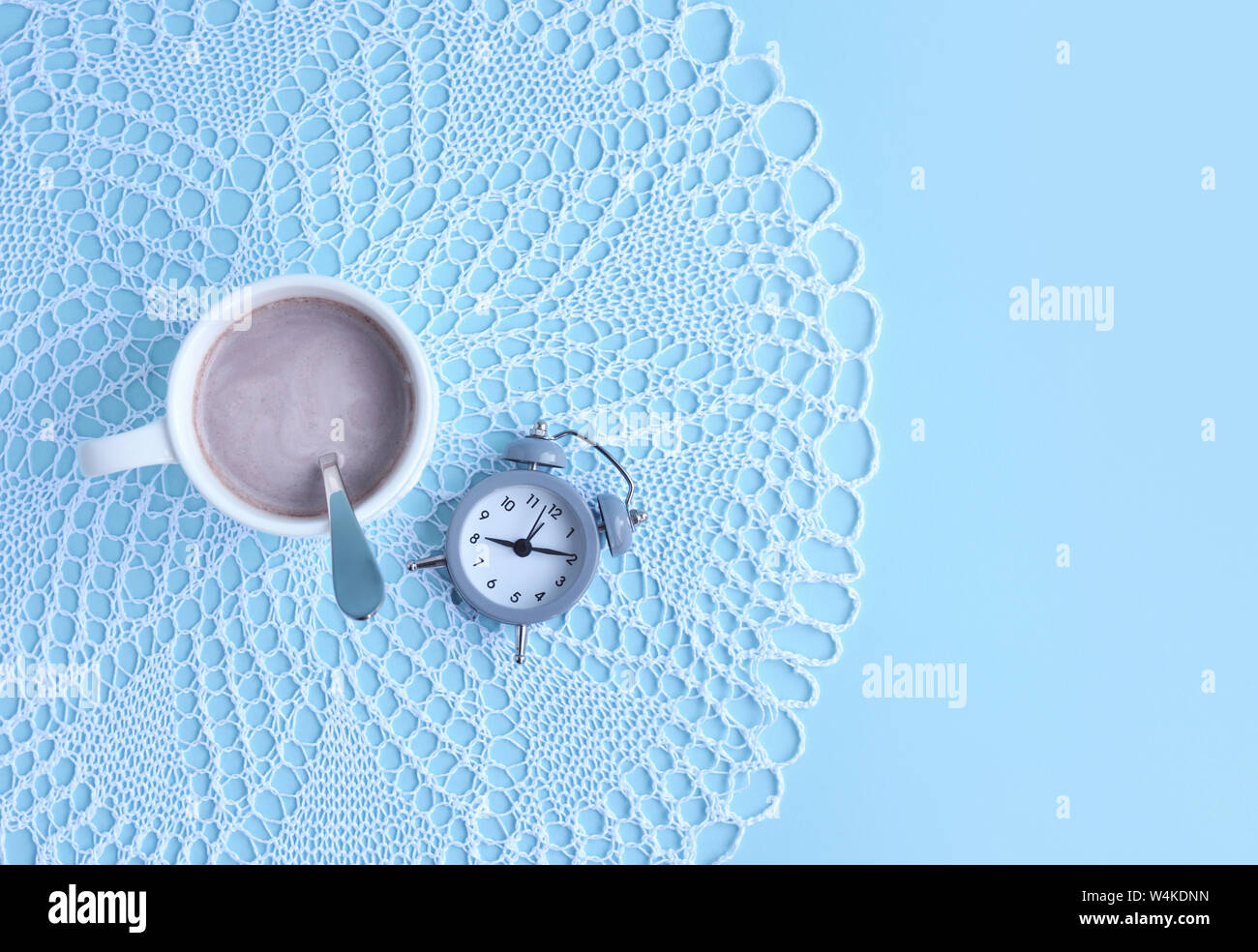 Morning cup of coffee and an alarm clock on a light blue background ...