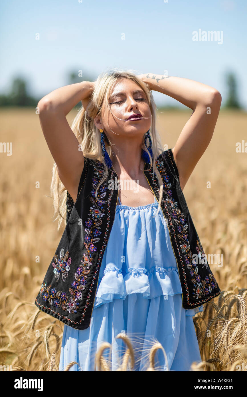 Beautiful girl in traditional costume in a wheat field Stock Photo