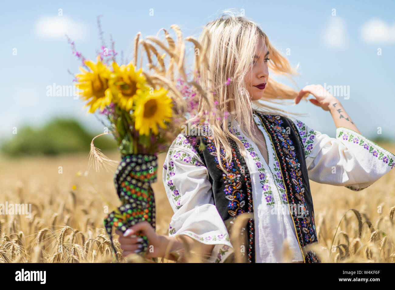 Beautiful girl in traditional costume in a wheat field Stock Photo