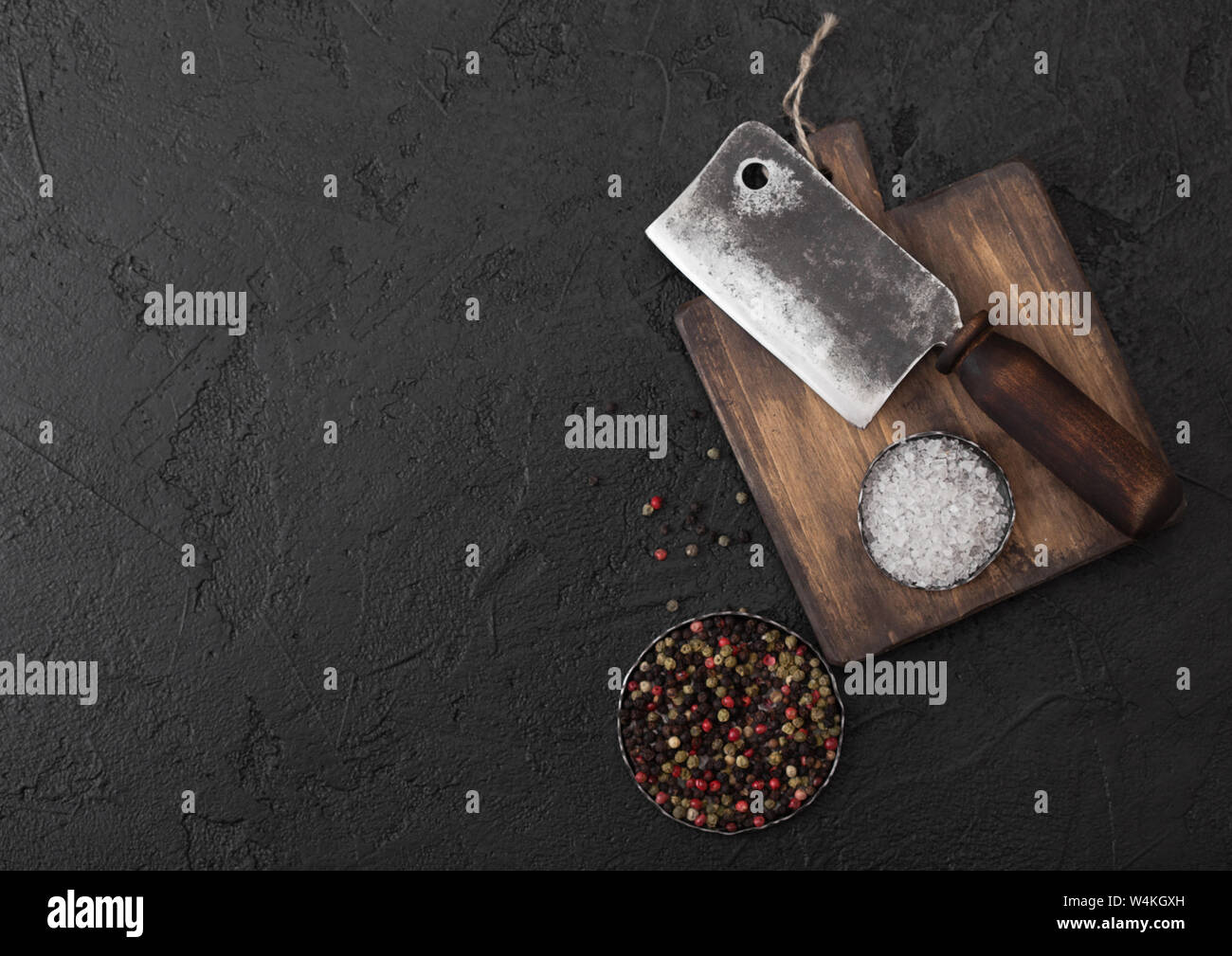 Vintage meat knife hatchet on vintage chopping board and black stone