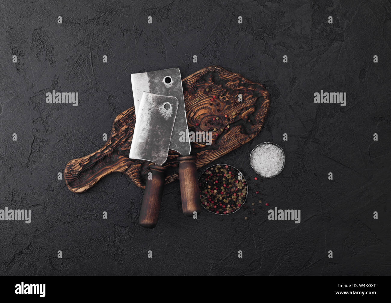 Vintage meat knife hatchet on vintage chopping board and black stone